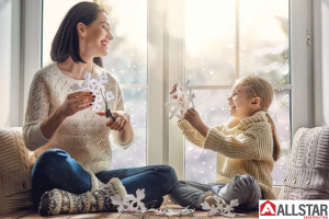 Mom and daughter making snowflakes by energy-efficient windows